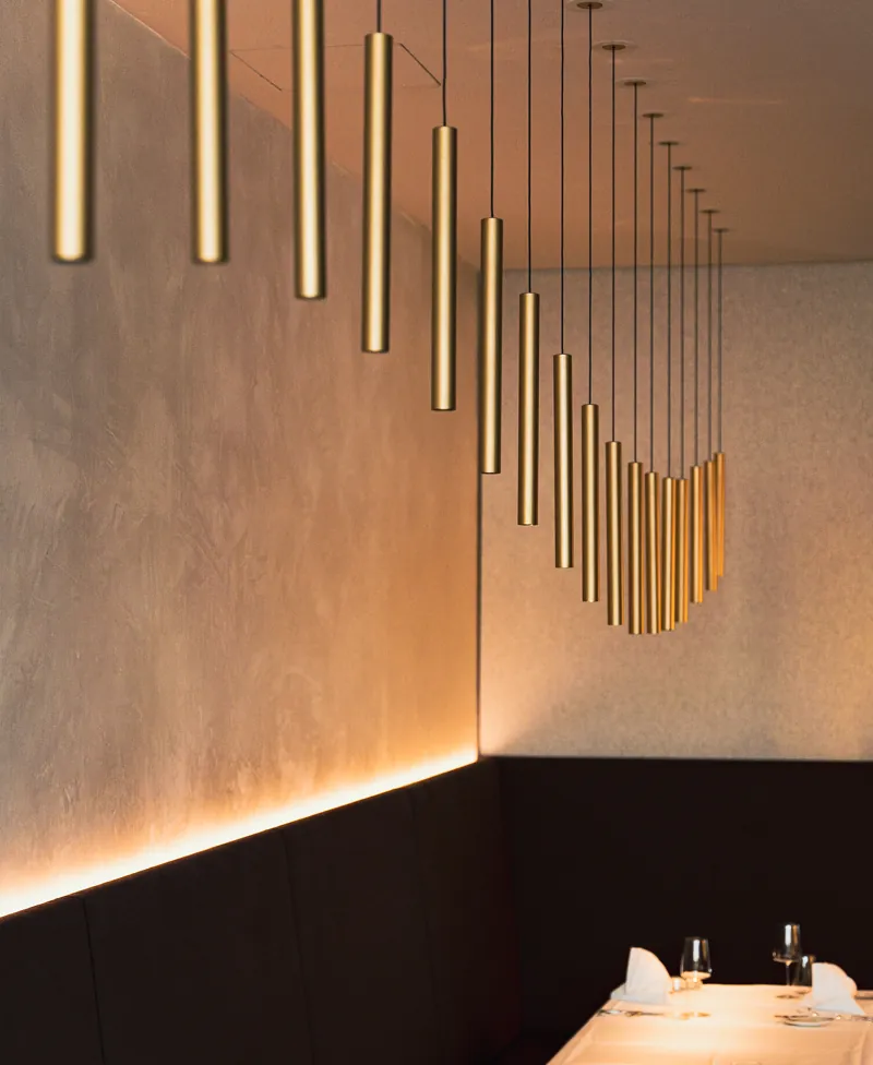 Goldene Pendelleuchten über einem Tisch